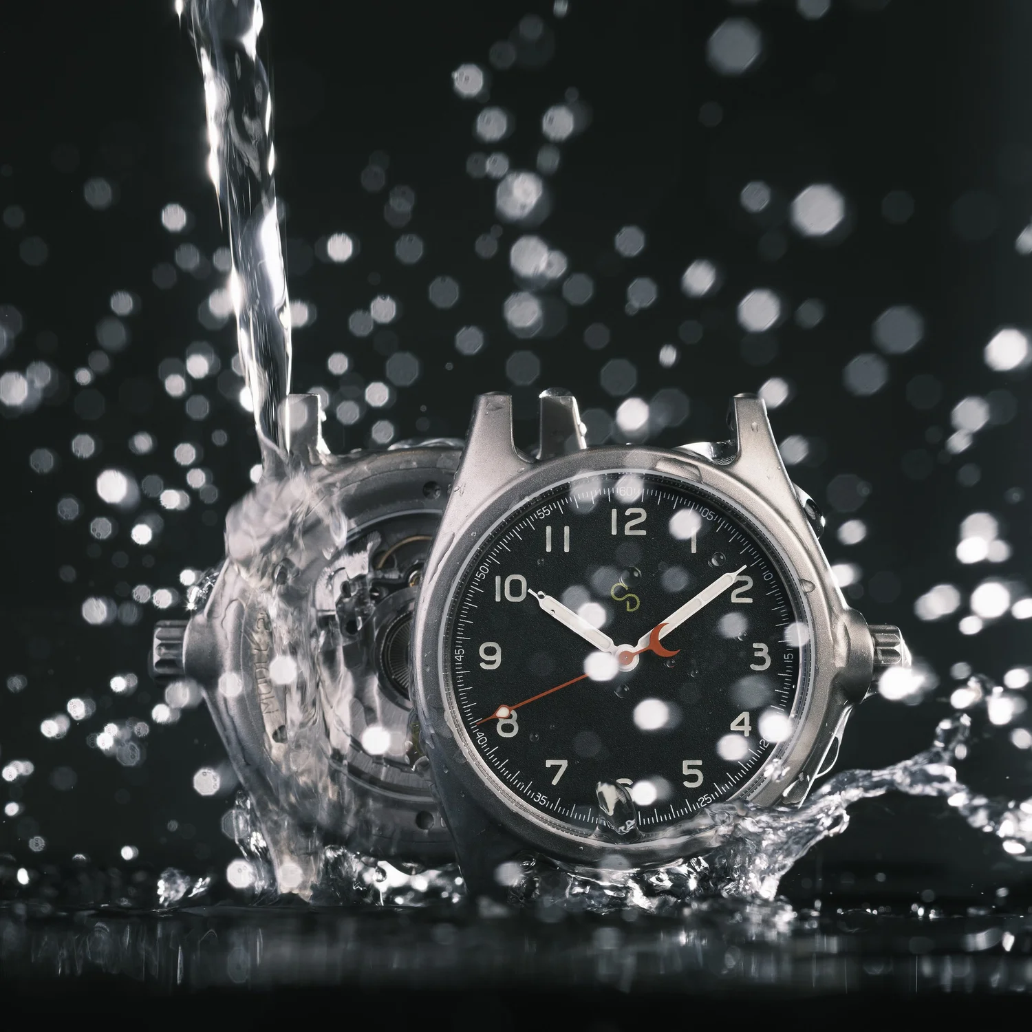 A close-up of a Clement Studios wristwatch with water splashing over it, highlighting its water resistance. The dark background makes the watch’s shiny details and water droplets stand out. Perfect for SEO-driven luxury showcases.